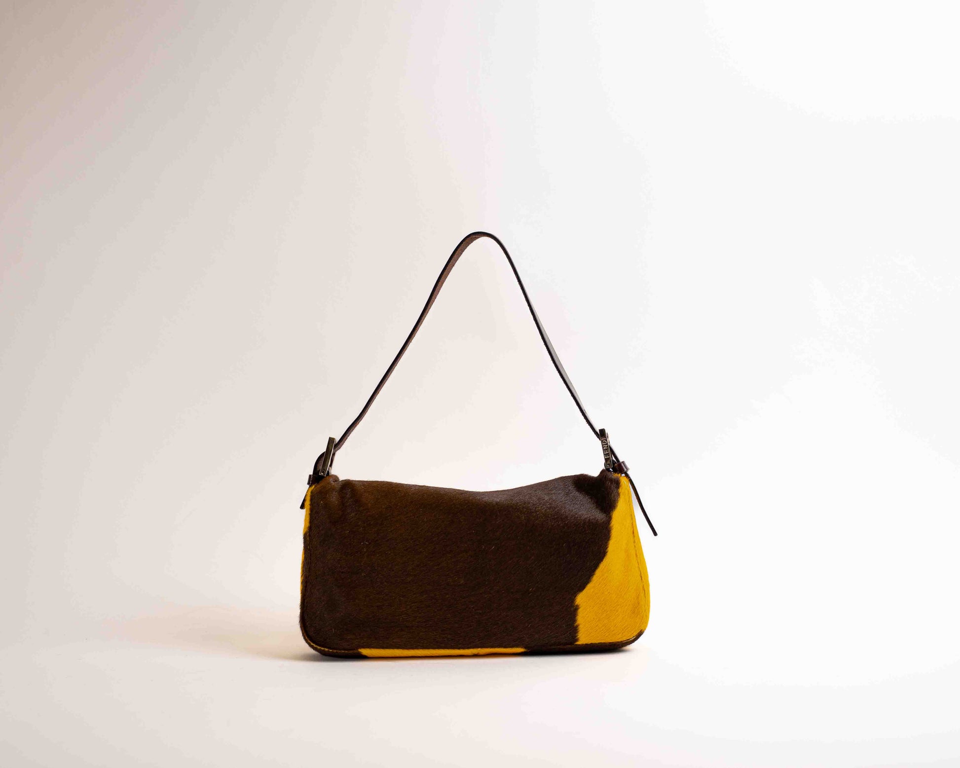 Brown and yellow handbag on a light gray background